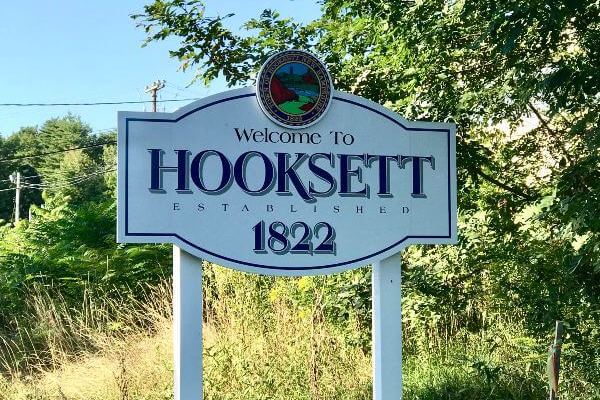 White wooden sign with words Welcome to Hooksett 1822