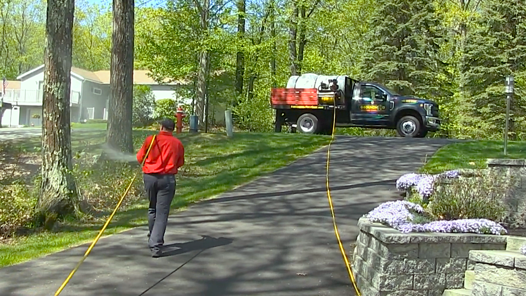 technician spraying yard for ticks