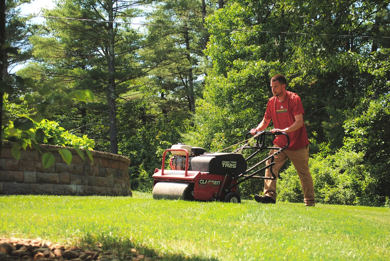 lawn care tech aerating a lawn in fall